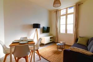 a living room with a table and a couch at Le Chanzy-Terrasse privative in Saumur