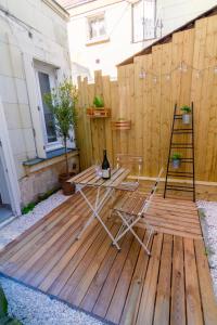 patio con tavolo e sedie su una terrazza in legno di Le Chanzy-Terrasse privative a Saumur