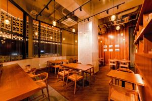a restaurant with wooden tables and chairs in a room at PROSTYLE TERRACE NAHA in Naha