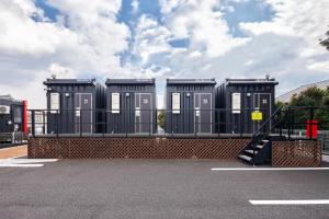 a row of portable toilets in a parking lot at HOTEL R9 The Yard Taketoyo in Taketoyo