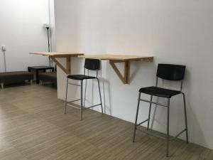two bar stools and a table in a room at Homey Hostel, Ipoh Town in Ipoh