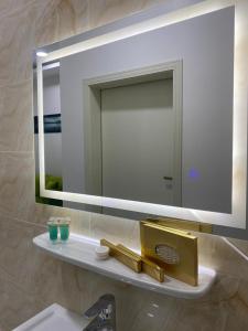 a bathroom with a mirror and a sink at شقق بيتي الفاخر للشقق للمخدومة Bayti Al Fakher Serviced Apartments in Laylá
