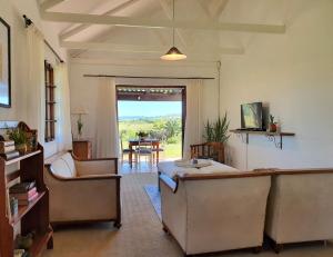 a living room with couches and a table with a view at Mansfield Private Reserve in Port Alfred
