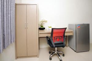 an office with a desk with a red chair and a refrigerator at D'Paragon Manduro in Solo