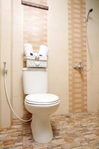 a bathroom with a toilet and a shower with towels at D'Paragon Manduro in Solo