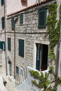 an old stone building with green shutters on it at Doria Apartments in Dubrovnik