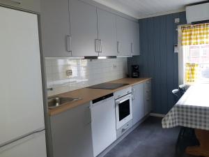 a kitchen with white cabinets and a sink at Lensmansgarden Marteinsgarden in Innfjorden