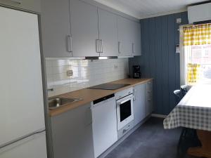 una cucina con mobili bianchi e un lavandino di Lensmansgarden Marteinsgarden a Innfjorden