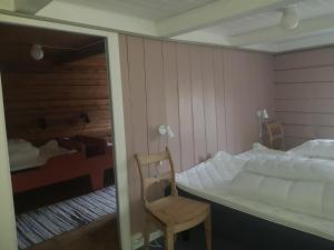 um quarto com uma cama, uma cadeira e um espelho em Lensmansgarden Marteinsgarden em Innfjorden