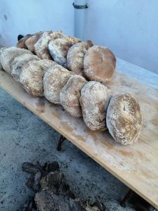 a bunch of loaves of bread on a wooden table at In campagna in La Spezia