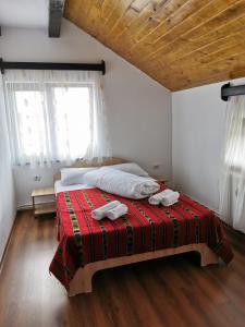 a bedroom with a bed with two towels on it at Pensiunea Alina in Baia de Fier