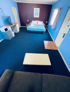 un soggiorno con letto e divano in camera di City East Motel a Melbourne