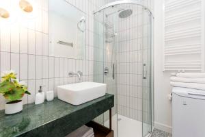 biała łazienka z umywalką i prysznicem w obiekcie Apartament 54 Old Town w Gdańsku +10 zdjęć
