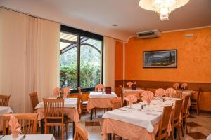 ein Restaurant mit Tischen und Stühlen und einem großen Fenster in der Unterkunft Hotel Florida in Limone sul Garda