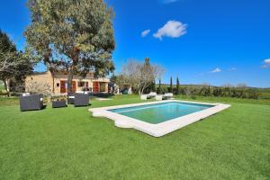 basen na trawniku z krzesłami i dom w obiekcie Finca Es Camp Pla 087 by Mallorca Charme w mieście Sineu