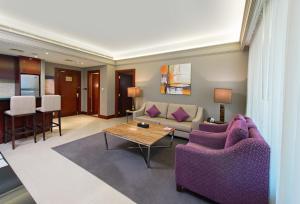 a living room with purple furniture and a table at Somewhere Hotel Apartment in Dubai