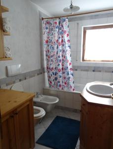a bathroom with a toilet sink and a shower curtain at Appartamento Norma in Val di Vizze