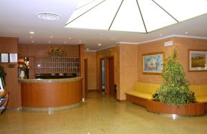 um lobby com uma sala de espera com uma árvore em Hotel Florida em Limone sul Garda
