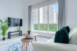 a living room with a couch and a large window at Stella Stays Radiant 1 BDR Dubai JVC Private Balcony in Dubai