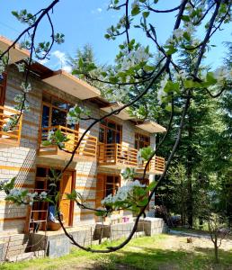 una casa con un árbol delante de ella en Getaway Stays Manali, en Manali