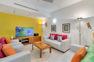 a living room with two couches and a tv at Elysium The Drift in Palm Cove