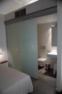 a bedroom with a bed and a bathroom with a sink at Casa Marcial (adults only) in Besalú