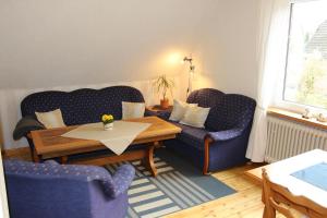 a living room with two blue chairs and a table at Ferienwohnung Ulrike Narjes in Volkwardingen