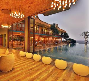 - un hall d'accueil avec une piscine et des chaises blanches dans l'établissement Thaproban Pavilion Resort and Spa, à Unawatuna
