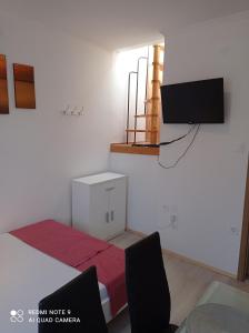 a room with a bed and a tv on the wall at Tavaszház Apartmanok in Balatonfüred