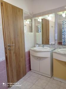 La salle de bains est pourvue de 2 lavabos et de 2 miroirs. dans l'établissement Tavaszház Apartmanok, à Balatonfüred
