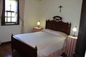 um quarto com uma cama e duas mesas com candeeiros em Quinta do Pomarinho em Arouca