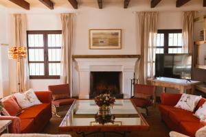 a living room with orange couches and a fireplace at Casa Rural Sansaba in Seville
