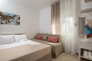a bedroom with a bed and a couch and a window at Studios Gianna in Toroni