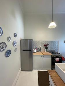 a kitchen with a refrigerator and blue and white plates on the wall at Webster Terrace in Ballarat