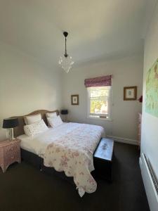 a bedroom with a large bed and a chandelier at Webster Terrace in Ballarat