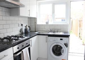 een keuken met een wasmachine en een wastafel bij Private & Comfortable 2 Bedroom Home away from Home in Stanwell