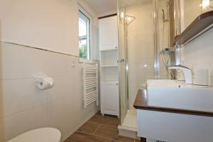 a bathroom with a toilet and a sink and a shower at Bungalow-Park Ostseenordstern in Wustrow +34 photos