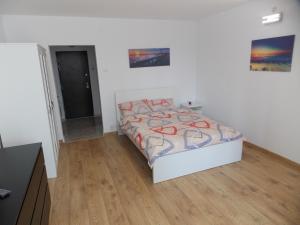 a bedroom with a bed and a wooden floor at Garsoniera moderna in Bucharest