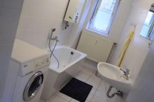 a white bathroom with a sink and a washing machine at Apartment Spring Creek in Merseburg