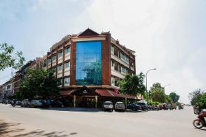a building with a large window on the side of a street at Almond Hotel Sothearos in Phnom Penh