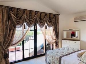 1 dormitorio con cama y ventana grande en Fun&Sun Two Villas For Big Families(16 person), en Belek