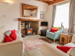 a living room with a fireplace and a couch at Cuckoo Cottage in Harrogate