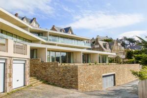 - une vue sur l'extérieur d'une maison avec un mur en briques dans l'établissement Les Terrasses de Piegu - vue mer et plage à 200 m, à Pléneuf-Val-André