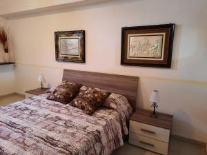 een slaapkamer met een bed en twee foto's aan de muur bij Casa Samuel in Galtellì