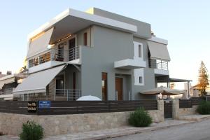 a large white house with a balcony at Sunny Villa by the beach Gournes in Gournes