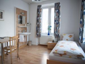 um quarto com uma cama, uma secretária e um lavatório. em Hotel Restaurant Raben em Linthal