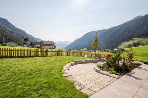 a backyard with a fence and a stone walkway at Residence Alpina in Santa Maddalena