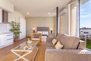 ein Wohnzimmer mit einem Sofa und einem Tisch in der Unterkunft Genteel Home Recaredo in Sevilla