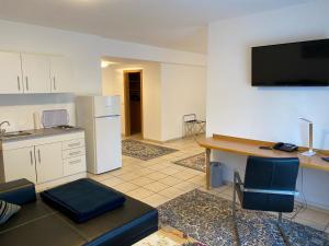 a kitchen with a table and a desk with a television on the wall at Hotel Europa in Ramstein-Miesenbach