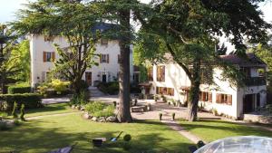 a large white house with trees in the yard at Gites du Caylar - Chambres et Appartments in Le Caylar